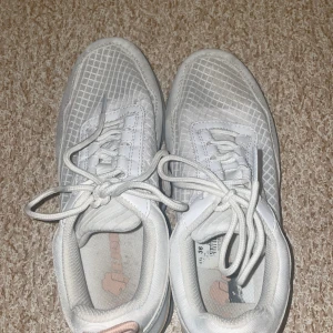 Vita sneakers från Lejon - Säljer ett par vita sneakers från Lejon i storlek 36 i bra skick. De har ett diskret rutmönster och snörning framtill. Perfekta för vardagsbruk och passar till det mesta. Sulan är i gott skick och skorna är bekväma att gå i. Fick de av en annan person så JAG har inte använt de.