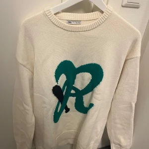 Vit stickad tröja från Zara - Säljer en vit stickad tröja från Zara i storlek L. Tröjan är långärmad och perfekt för både höst och vinter. Supermysig och stilren, passar till alla tillfällen!