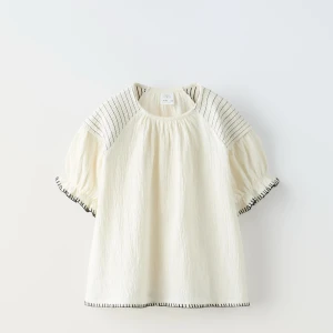 Vit blus med broderade detaljer - Säljer en söt vit blus från Zara med korta ärmar och fina broderade detaljer i svart. Perfekt för vår och sommar! Skriv för fler bilder 🩷