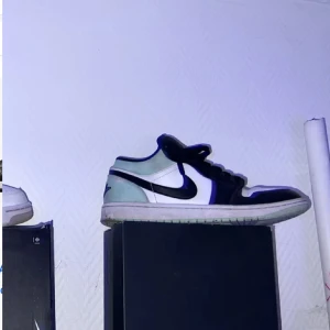 Air Jordan 1 Low 'Tie-Dye' - Säljer ett par Air Jordan 1 Low 'Tie-Dye' i svart och vitt med coola tie-dye detaljer. Skorna har en klassisk design med snörning och är i bra skick. Perfekta för både vardag och fest! Storleken är 42 