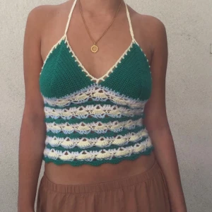 Grön och vit virkad halterneck-top - Säljer en superfin virkad halterneck-top i grönt och vitt. Toppen är croppad och har ett snyggt snörningsmönster i ryggen. Så ledsen över att sälja den här. Perfekt för sommardagar och festivaler! 💚🤍