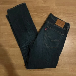 Levi's jeans i mörkblå denim - Säljer ett par klassiska Levi's 514 i mörkblå denim. De har en rak passform och är i mycket bra skick. Strl 33 32. 