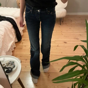 Mörkblå lågmidjade jeans - Säljer ett par snygga mörkblå jeans i bra skick. De har en klassisk femficksdesign och är lågmidjade med en bootcut-stil. Perfekta för både vardag och fest! Passar bra till en t-shirt eller en snygg blus.