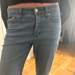 Blå jeans med broderad detalj - Säljer ett par snygga blå jeans i bra skick. De är lågmidjade  och har en straight passform som är både bekväm och stilren. Jeansen har en fin broderad detalj på bakfickorna som ger dem lite extra karaktär. Perfekta för både vardag och fest! Storlek 30/32
