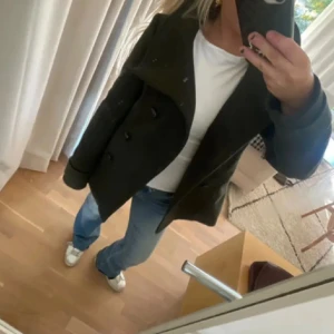 Svart kappa - Säljer en stilren mörkgrön kappa i mycket bra skick. Den har en klassisk design med knappar framtill och en elegant krage. Passar både till vardags och lite finare tillfällen (lånade bilder)