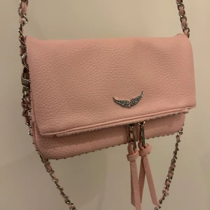 Rosa Zadig axelväska - Säljer en superfin rosa Zadig axelväska i syntetmaterial med silver kedjedetaljer. Väskan är köpt i Spanien, Barcelona. Perfekt för både vardag och fest! 💖