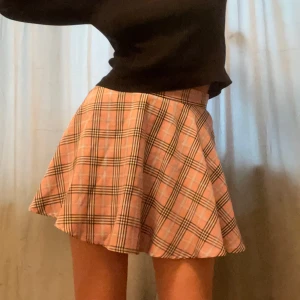 Rutig minikjol - Rosarutig minikjol. Midja 35 cm. Längd 41 cm.