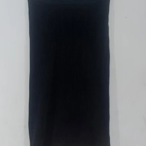 Svart ribbad kjol från Lindex - Säljer en stilren svart ribbad kjol från Lindex i storlek 158/164. Kjolen har en slits på sidan som ger en snygg detalj och är perfekt för både vardag och fest. Den är i mycket bra skick och passar till alla tillfällen. Perfekt för höst och vinter! 🖤