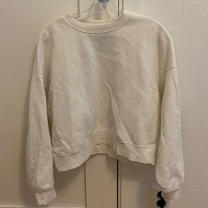 Beige sweatshirt - Säljer en mysig vit sweatshirt i storlek M. Perfekt för en avslappnad stil med långa ärmar och ribbade muddar. Passar bra till både jeans och mjukisbyxor. Perfekt för alla årstider! Den är nopprig