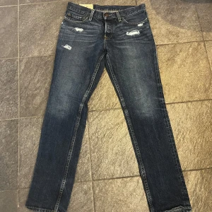 Blå jeans från Hollister - Säljer ett par riktigt snygga blå jeans från Hollister i bra skick. De har en slim passform med slitningar. Hör av er vid intresse och funderingar, priset är inte fast och kan även bytas mot ett annat par.