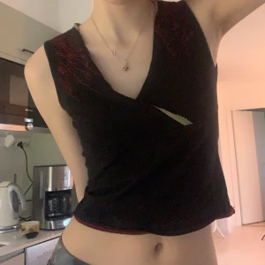 St Martins topp - Omlott topp från st martins, cool grön spets vid kanten och röda detaljer på axlarna, häftigt mönster på baksidan också som inte syns så bra på bild, kan fixa bättre bilder! Den gröna kanten har vikt sig inåt på bilden men går hela vägen!