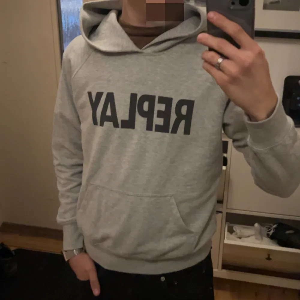 Säljer en snygg grå hoodie från Replay i storlek S. Den har en stor svart logga på framsidan och en klassisk känguruficka. Perfekt för en avslappnad stil och passar till alla årstider. Hoodien är i mycket bra skick och superbekväm! jag är 183 och väger ca 70 kg. pris kan diskuteras vid snabb affär. det är bara att skriva vid funderingar😊. Tröjor & Koftor.