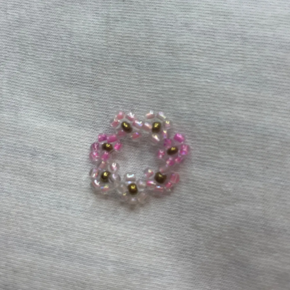 Säljer en söt ring med blommor i rosa och vita nyanser. ringen ger en fin touch med sina små blommor. Perfekt för att liva upp vilken outfit som helst! 🌸✨. Asusteet.