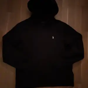 Säljer en svart fleece hoodie från Ralph Lauren i storlek L för pojkar 6-14 år sitter som en xs/xs vuxen. Den har en klassisk design med en liten vit logga på bröstet och en praktisk känguruficka. Perfekt för kyliga dagar! 🖤