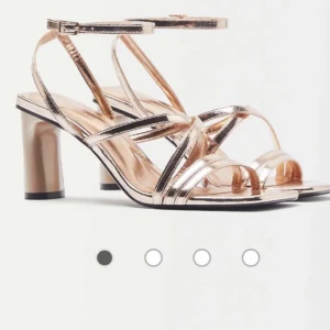 Festklackar  - Snygga klackar i glänsande champagnefärg med remmar och en bekväm klack. Perfekta för festliga tillfällen eller en utekväll. De har en fyrkantig tå och justerbara remmar för bästa passform.