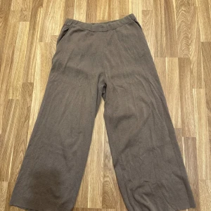 Bruna vida byxor - Brun/beiga vida byxor i storlek M från Åhléns! Byxorna har en loose passform och är superbekväma att ha på sig. 