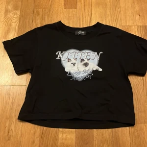 Svart t-shirt med kattmotiv från Zone - Cool svart t-shirt från Zone med ett gulligt kattmotiv och texten 'Kitten Love Me Always!' på framsidan. Perfekt för kattälskare som vill ha en avslappnad stil.