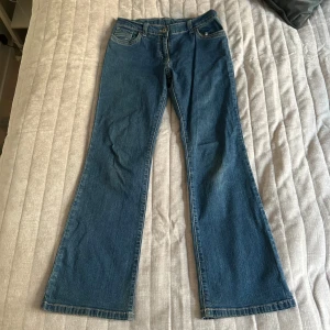 Blå bootcut jeans - Snygga blå bootcut jeans med klassisk femficksdesign. Lågmidjade jeans flare jeans lowwaist jeans. Perfekta för en avslappnad stil med en touch av retro. Storlek M men skulle säga mer S.