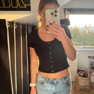 Svart ribbad topp - Säljer min söta ribbade topp med knappar framtill från HM. Toppen är kortärmad och har en croppad design💞nypris 160kr