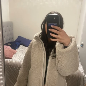 Beige pile jacka från H&M - Mysig beige teddyjacka med dragkedja framtill. Jackan har en hög krage och långa ärmar, perfekt för kyliga dagar. Den har en avslappnad passform och stora fickor. Helt oanvänd med lappar kvar på!