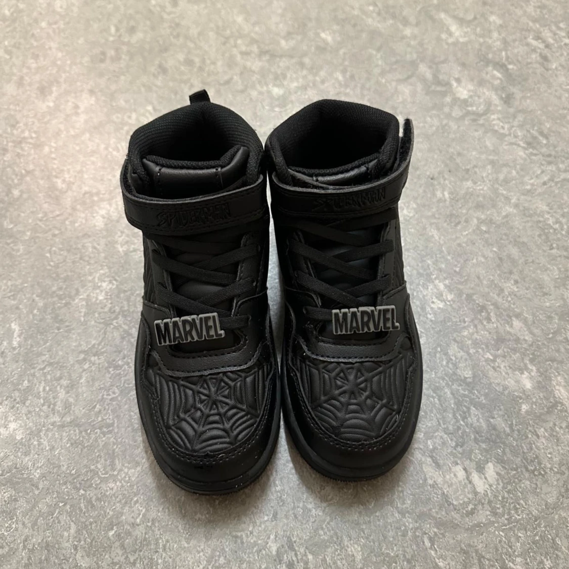 Svarta Marvel sneakers med spindelnätsmönster