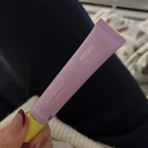 Glow Hyaluronic Lip Oil från Budgie - Säljer en Glow Hyaluronic Lip Oil från Budgie. Den kommer i en lila tub med gul kork och är perfekt för att ge läpparna en återfuktande glans💓