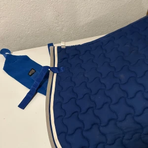 Schabrak och lindor - Royalblått dressyrschabrak storlek ponny av märket hansbo sport med 4 matchande lindor märket shires. I mycket fint skick! 