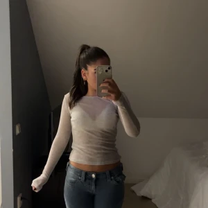 Vit ribbad långärmad topp - Säljer en stilren vit ribbad topp med långa ärmar. Den är lite genomskinlig och Perfekt för lager-på-lager eller som den är. Enkel och mångsidig design som passar till det mesta. Hör av dig vid intresse!🫶🏽