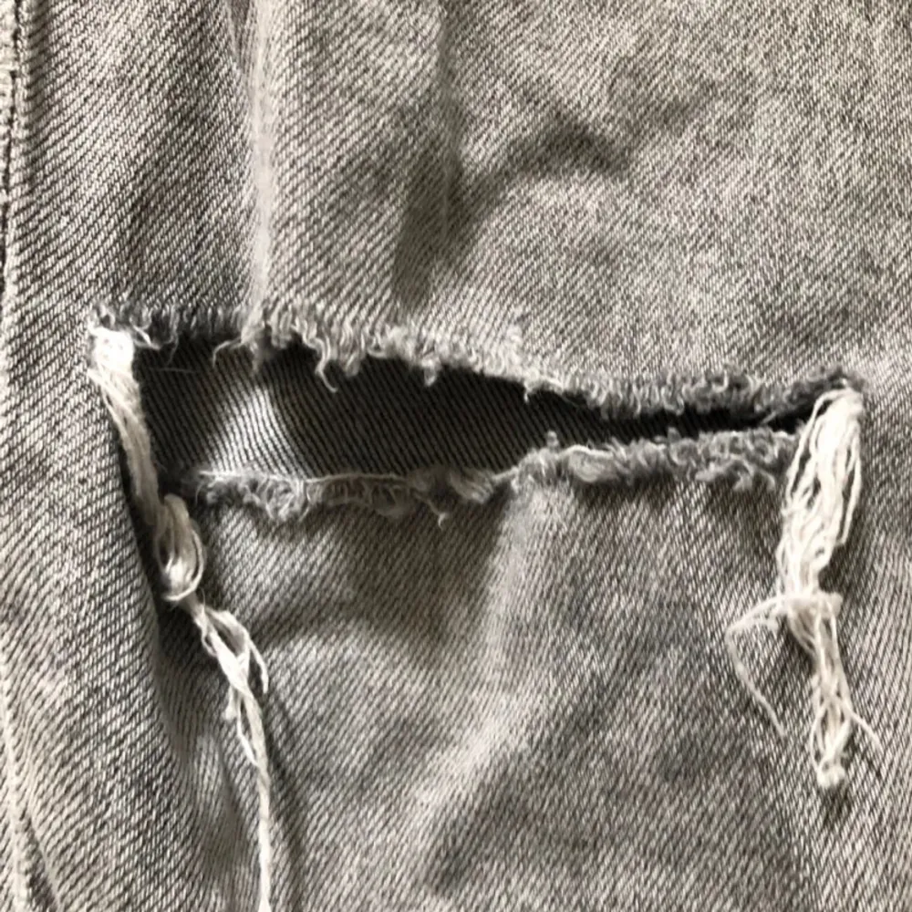 Säljer ett par grå jeans från H&M i storlek S. De har en snygg slitning på ena benet och en klassisk femficksdesign. Perfekta för en avslappnad look.. Farkut & Housut.