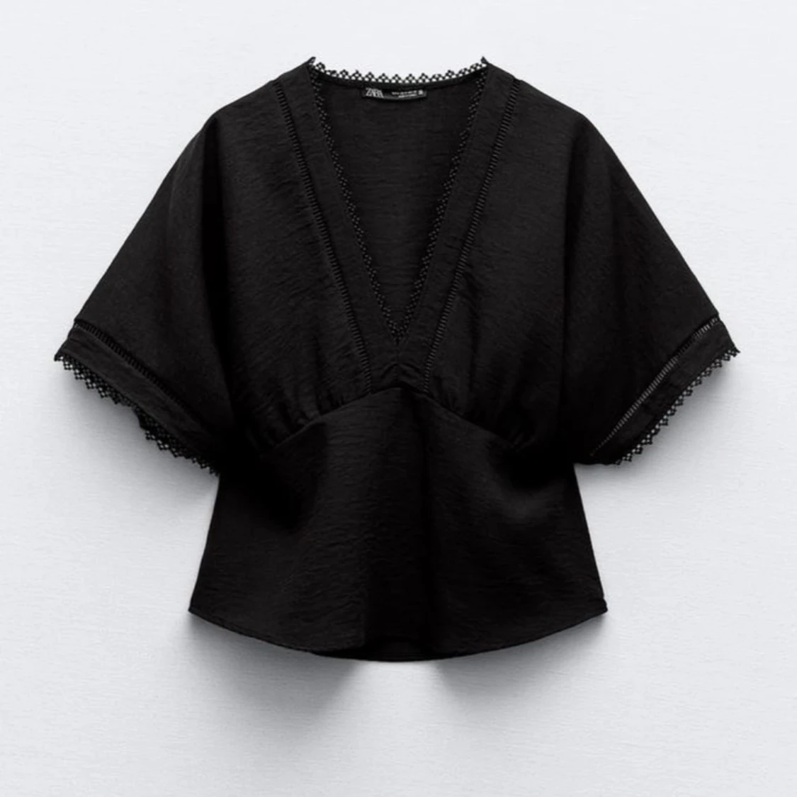 Svart blus med spetsdetaljer