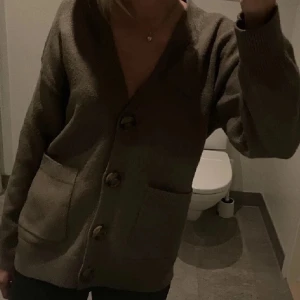 Brun kofta med knappar - Mysig brun kofta med stora knappar framtill och två fickor. Lånad billddd!