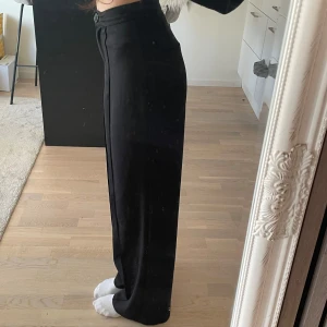 Svarta kostymbyxor från Bubbleroom - Snygga svarta kostymbyxor från Bubbleroom i storlek XS. Byxorna har en hög midja och en rak passform med knapp och dragkedja framtill. ”Fickor” på baksidan. Perfekta för en stilren look.