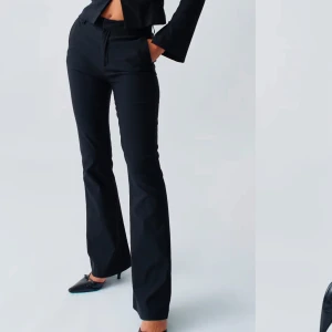 Svarta kostymbyxor med bootcut - Snygga svarta kostymbyxor med bootcut. Perfekta för en stilren look. Byxorna har en elegant passform och är tillverkade i ett bekvämt material. Endast använda en gång! 