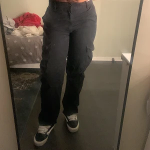 Svarta cargobyxor - Säljer ett par svarta cargobyxor med flera praktiska fickor. Byxorna har en loose passform och är perfekta för en avslappnad stil. De är midwaist och passar bra till sneakers.originellt köpt från pull and bear