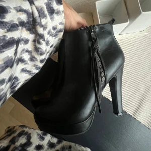 Svarta klackar/boots med dragkedja - Snygga svarta boots från Attitude med hög klack och dragkedja på sidan. Dom är använda vid två tillfällen så dem är som nya. Perfekta för en stilren look.