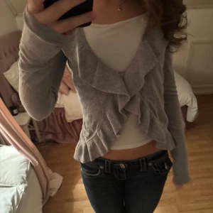 Grå kofta från Gina Tricot - Grå kofta från Gina Tricot, gulliga volanger och en fin grå färg. I storlek xs. PRIS KAN DISKUTERAS❤️