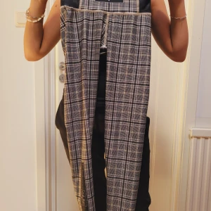 Rutig träninstights från Gavelo - Snygga rutiga byxor i återvunnen polyester och spandex. De har en elastisk midja och ett klassiskt rutmönster i svart och vitt. Perfekta för en stilren look.