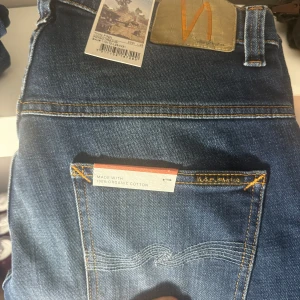 Blå jeans från Nudie Jeans w31 L28 - Snygga blå jeans från Nudie Jeans i 100% ekologisk bomull. De har en klassisk femficksdesign och en snygg tvättad look. Perfekta för en avslappnad stil.