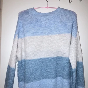 Stickad tröja  - Mysig stickad tröja från NA-KD i olika färger av ljus blå och vit. Tröjan har ett randigt mönster och långa ärmar, perfekt för kyligare dagar.  Den har en bekväm passform❤️kan sänkas i pris☺️