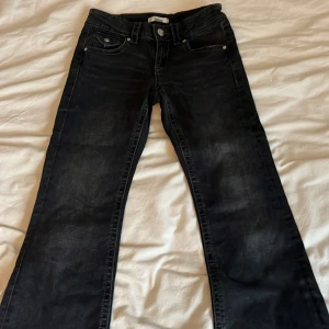 Svarta jeansbyxor - Snygga svarta jeansbyxor med bootcut-stil. De har klassiska fem fickor och en knapp- och dragkedjestängning. Perfekta för en avslappnad look.