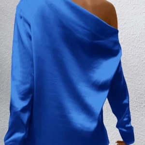 Blå sidenblus - Elegant blå blus i siden med en vacker glans. Perfekt för speciella tillfällen med sin lyxiga känsla och djupa färg.