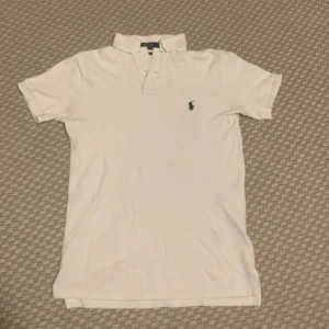 Vit pikétröja från Ralph Lauren - Den är i bra skick. Storlek XS men passar jättebra på S också. Den har en pytteliten slitning i en av armhålorna och någon liten fläck som inte syns.