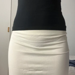 Vit kjol från Nelly - Säljer en stilren vit kjol från Nelly i storlek XS. Kjolen har en enkel och elegant design som passar perfekt till olika tillfällen. Den är gjord i ett mjukt och bekvämt material.