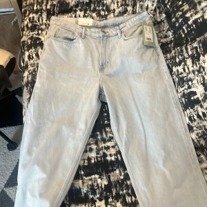 Ljusa jeans från H&M - Säljer ett par ljusa jeans från H&M med loose fit. De har en klassisk femficksdesign och stängs med dragkedja och knapp. Perfekta för en avslappnad stil.