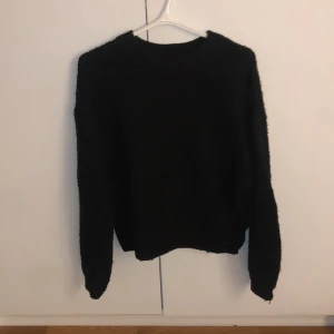 Svart tröja från NA-KD - Säljer en stilren svart stickad tröja från NA-KD. Perfekt för kyligare dagar med sin långärmade design. Tröjan har en klassisk passform och är lätt att matcha med olika outfits. Ett måste i garderoben för den som gillar enkel och tidlös stil. Som du kanske ser på den sista bilden så är den lite fläckig på lappen i nacken, annars inga tecken på användning🥰🥰