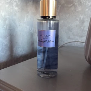 Victoria's Secret Midnight Bloom Fragrance Mist - Säljer en Victoria's Secret Midnight Bloom Fragrance Mist. Flaskan är genomskinlig med en blå etikett och har en gyllene kork. Perfekt för att fräscha upp din doft med en blommig och mystisk ton. Använd men mer av halva parfymen finns kvar!