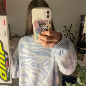 Blå och vit stickad tröja från Shein - Säljer en mysig blå och vit stickad tröja från Shein med ett zebramönster. Tröjan har långa ärmar och en bekväm passform. Perfekt för kyliga dagar. Hör av dig vid intresse! 💙