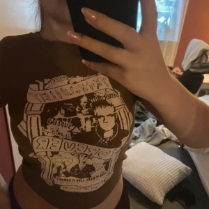 Brun t-shirt med tryck - Säljer en brun t-shirt med ett coolt tryck på framsidan. T-shirten har en normal passform och korta ärmar. Perfekt för en avslappnad stil.