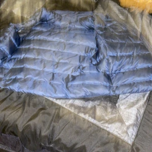 Blå pufferjacka - Säljer en snygg blå pufferjacka i bra skick. Perfekt för kyliga dagar med sitt quiltade mönster och långa ärmar. Jackan har en dragkedja framtill och är gjord av syntetmaterial. Den är både stilren och praktisk för höst och vinter. Har kvitto säljer för 200kr kontanter gärna Storlek 146/152