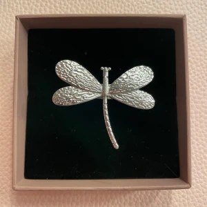 Silverfärgad trollslända ring - Superfin ring i form av en trollslända i silverfärg. Den har en detaljerad design med texturerade vingar som ger en elegant look. Perfekt för att lägga till en unik touch till din outfit. Passar både till vardags och festliga tillfällen. Justerbar och helt ny! (Låda tillhör inte)